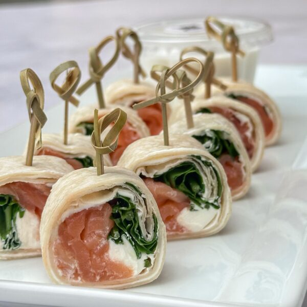 24 Rolls de carpaccio de salmón, queso crema y rucula con lactonesa de ajo para untar